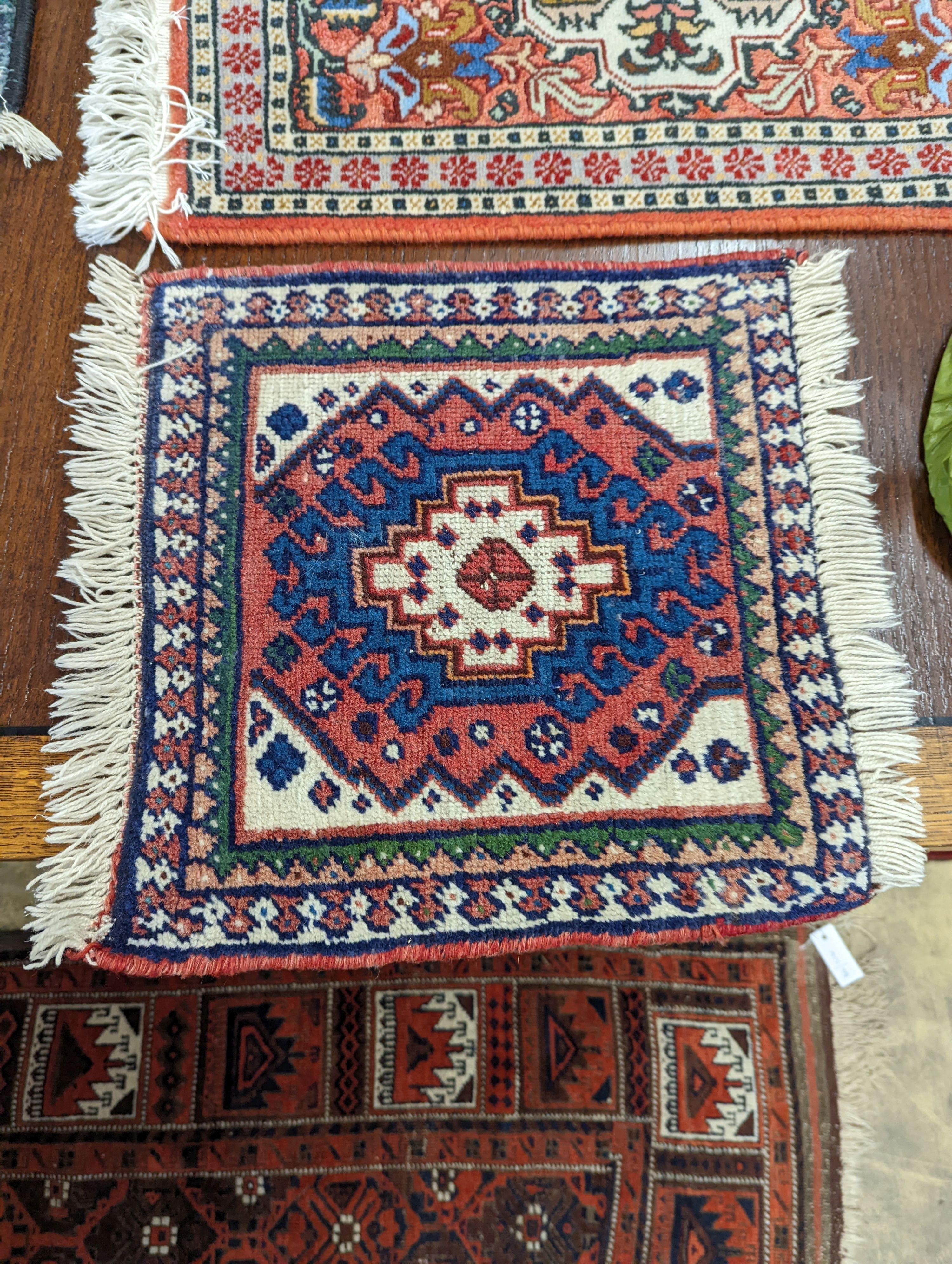 A Caucasian red ground mat, a Bokhara mat, three others and a blue ground rug, largest 136 x 80cm (6)